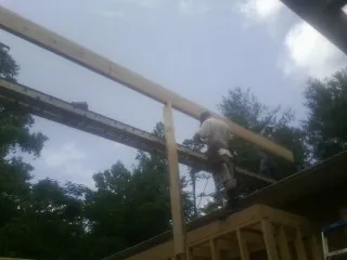 Carpenter setting a ridge beam over a new addition frame — Ice Dam Removal by Roofing Brothers in Trimble