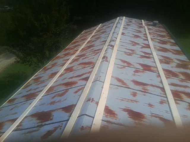 Rusted metal roof panels with new wood purlins before replacement — Storm Damage Roof Repair in Trimble by Roofing Brothers