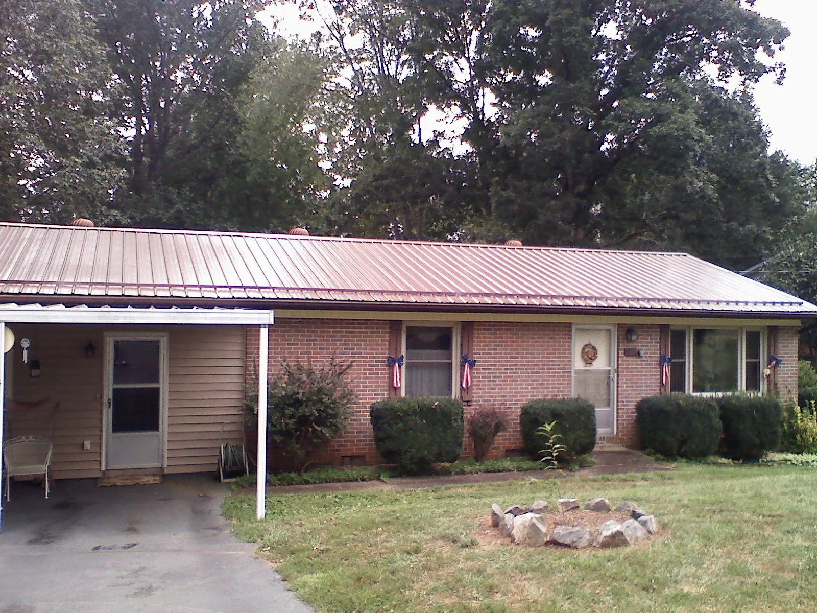 Bronze metal roof and carport on a brick ranch home — Roof Repair work by our crew in Trimble